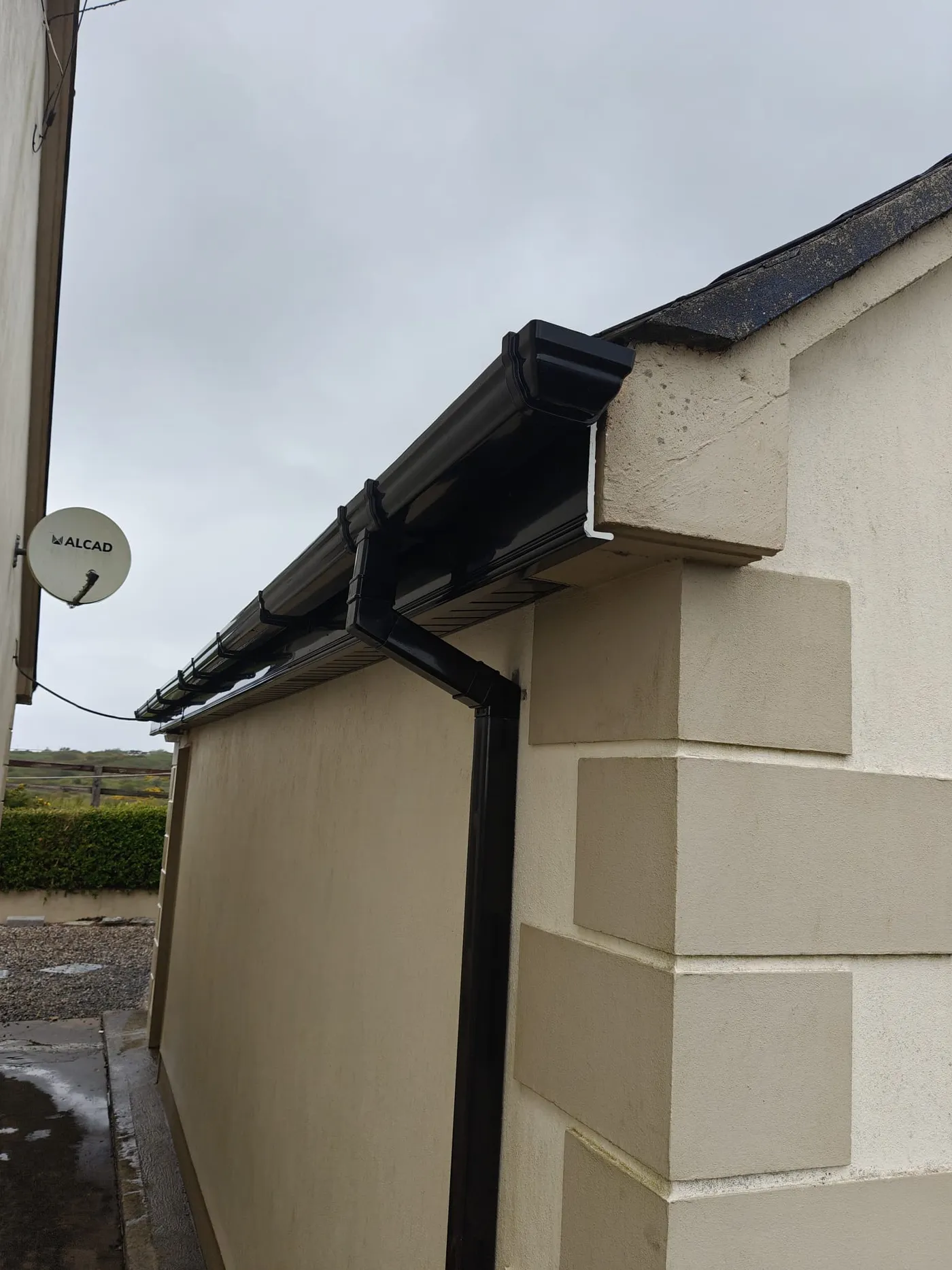 Black uPVC gutter, fascia, soffit and downpipe fitted on a rendered house