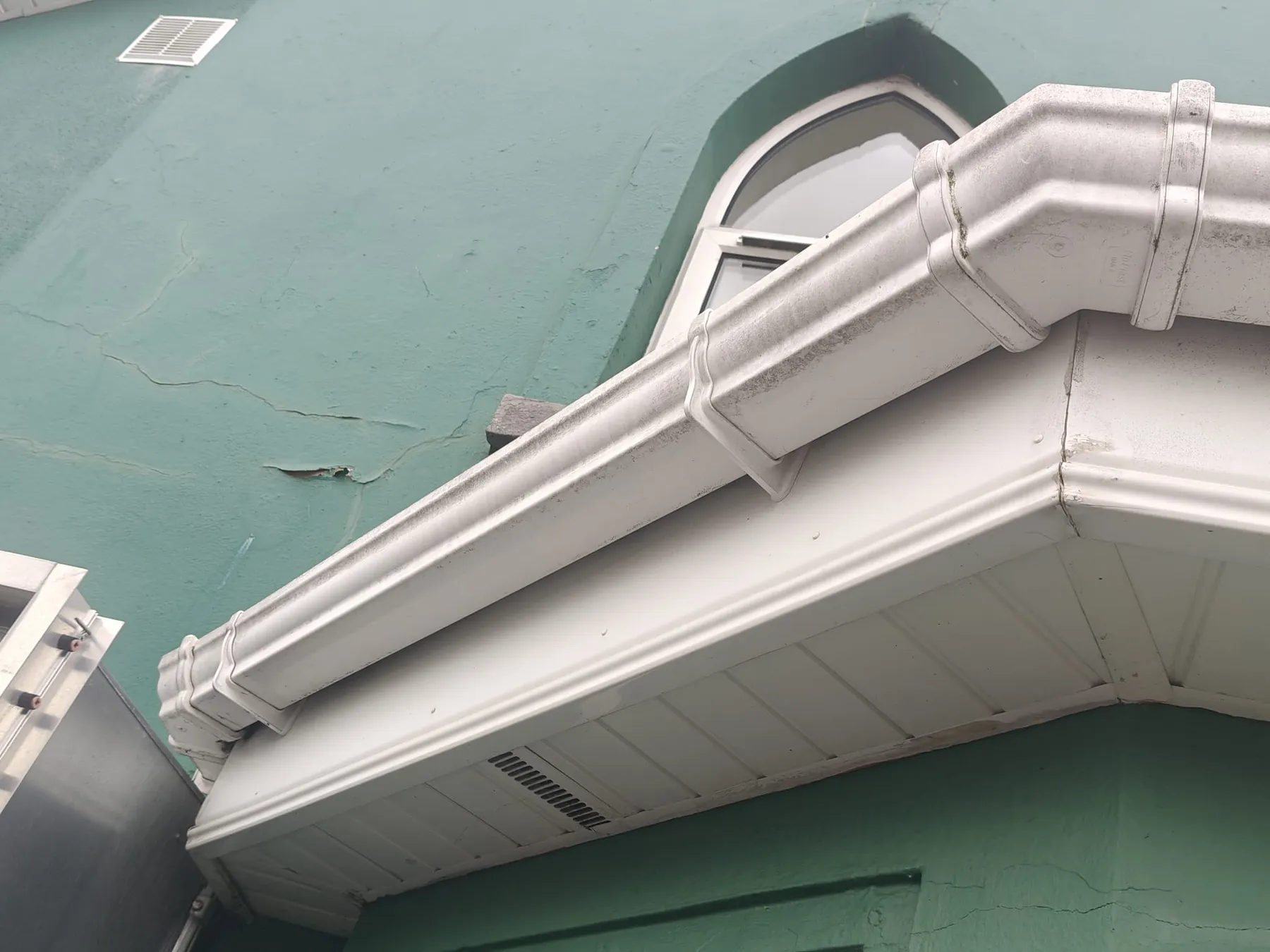 Close-up of a white uPVC gutter, fascia and vented soffit on a commercial building